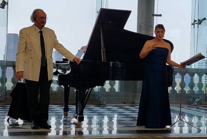 Un hombre en traje parado enfrente de un piano

Descripci�n generada autom�ticamente con confianza media