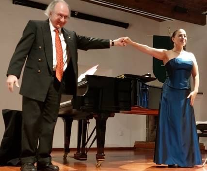 Una persona en traje parado enfrente de un micr�fono

Descripci�n generada autom�ticamente con confianza baja