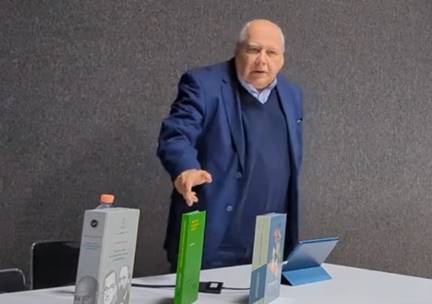 Un hombre en traje parado enfrente de una caja

Descripci�n generada autom�ticamente con confianza media